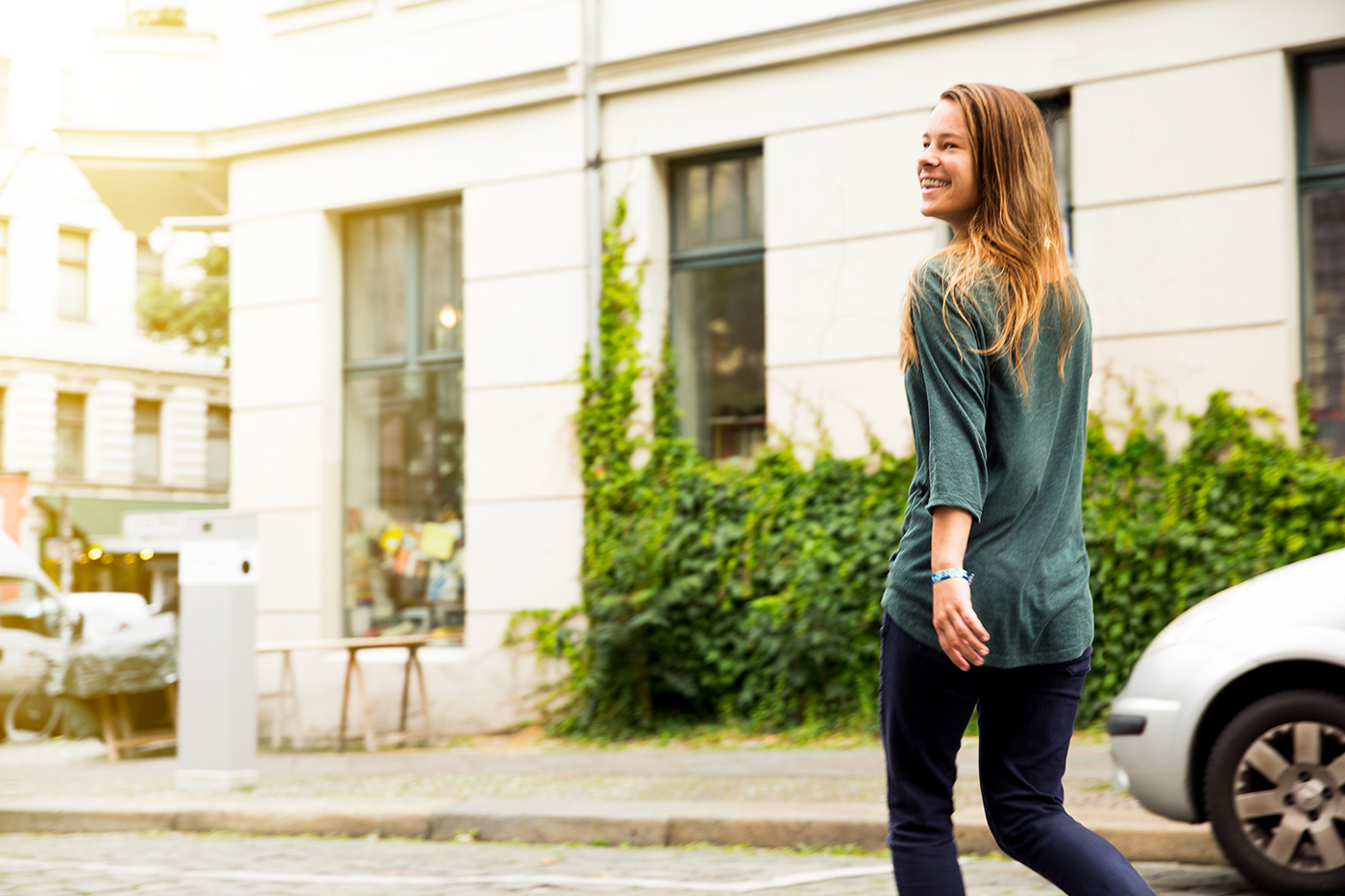 A young woman crossing the street with a natural smile