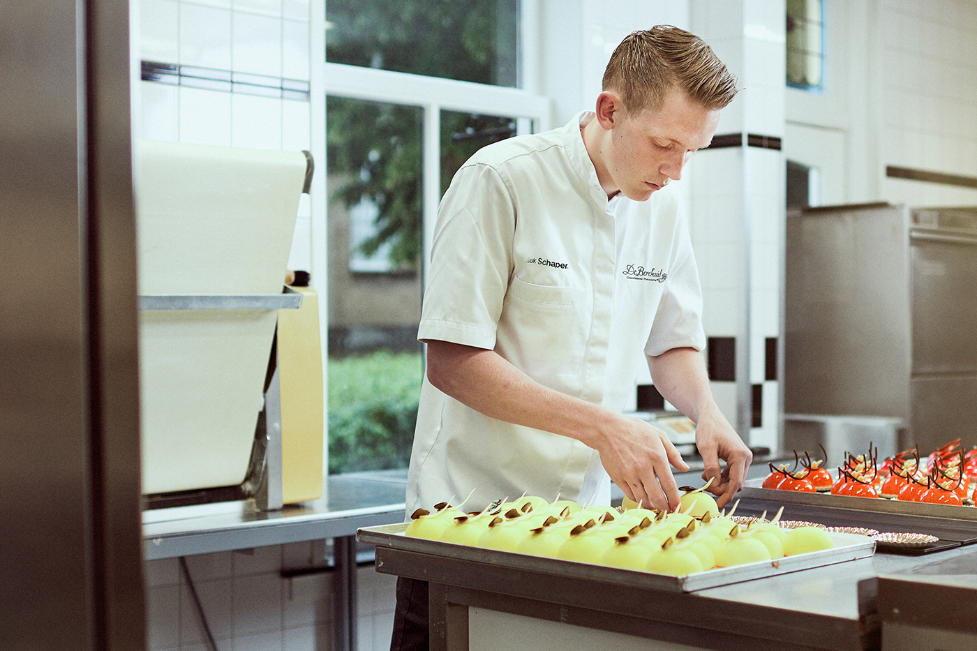 A young man working in a kitchen with chocolates.